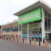 Homebase store with closing sale signs and discounts, large green sign above entrance, customer entering store
