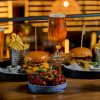 Burgers with chips and beer on a wooden table in a cosy pub setting, perfect for a casual dining experience