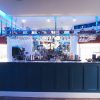 Stylish modern bar interior with illuminated blue accents, glasses on display, and an assortment of liquor bottles