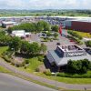 Aerial view of a retail park with popular fast food restaurants and shops, surrounded by greenery and roads