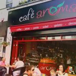 Café Aroma with outdoor seating, offering coffee, juices, pasta and desserts on a sunny day