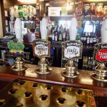 Pub bar with four beer taps, featuring Rosie's Pig, Fursty Ferret, First Call and Tangle Foot, with spirits in background