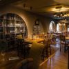Cosy restaurant interior with wooden flooring, elegant lighting, and an inviting atmosphere for dining and socialising