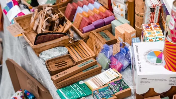 Handmade sustainable products displayed on a market stall, featuring soaps, eco-friendly packaging, and natural goods