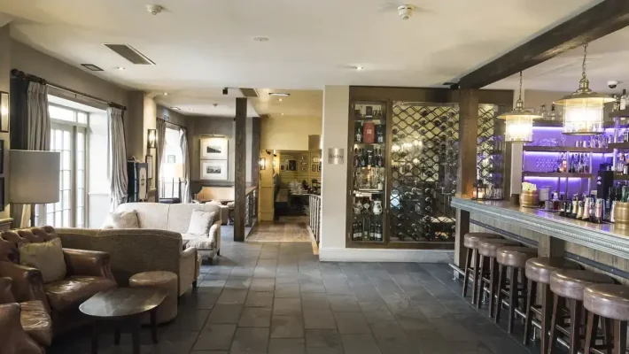 Cosy bar and bistro interior with plush seating, a well-stocked bar, and ambient lighting creating a welcoming atmosphere