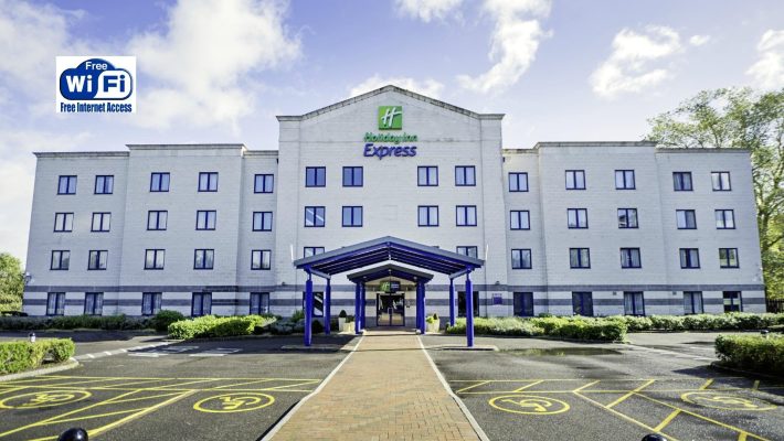 Front view of hotel offering free Wi-Fi, featuring a modern entrance and designated parking spaces